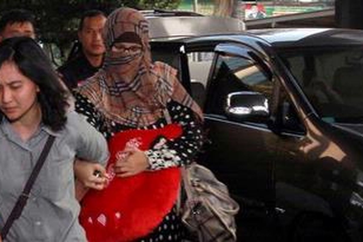 Buron Komisi Pemberantasan Korupsi, Neneng Sri Wahyuni (mengenakan penutup wajah) ditangkap di kawasan Pejaten, Pasar Minggu, Jakarta Selatan, Rabu (13/6/2012). Istri terpidana Nazaruddin ini, diintai KPK di Bandara Soekarno-Hatta dan ditangkap di rumahnya, di kawasan Pejaten.
