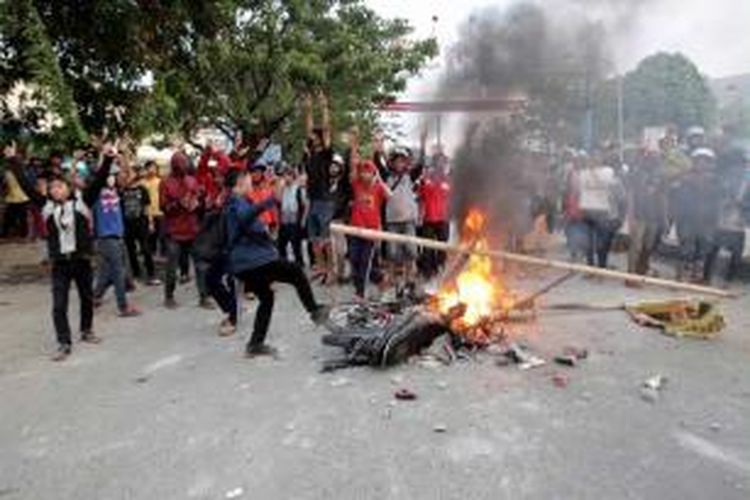 Warga merusak dan membakar motor milik mahasiswa Universitas Muhammadiyah Makassar saat keduanya terlibat kerusuhan di Jalan Sultan Alauddin, Makassar, Sulawesi Selatan, Selasa (18/11/2014).