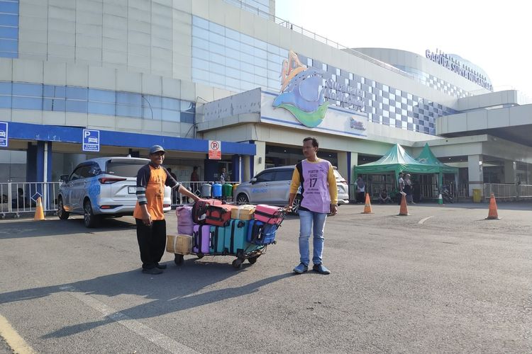 Mukti dan Abdul saat akan membawa barang penumpang menggunakan kereta dorong di GSN Pelabuhan Perak