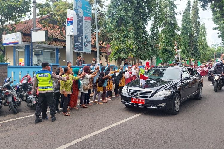Warga Salatiga melambaikan tangan kepada Presiden Jokowi yang melintas