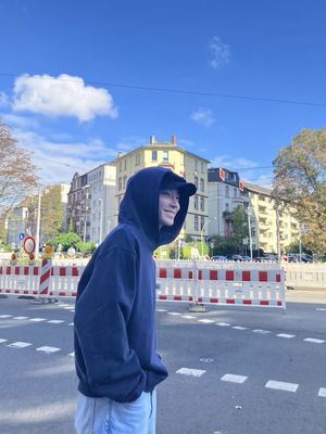 Hwang In Yeop mengenakan hoodie navy yang dipadukan dengan celana jeans.
