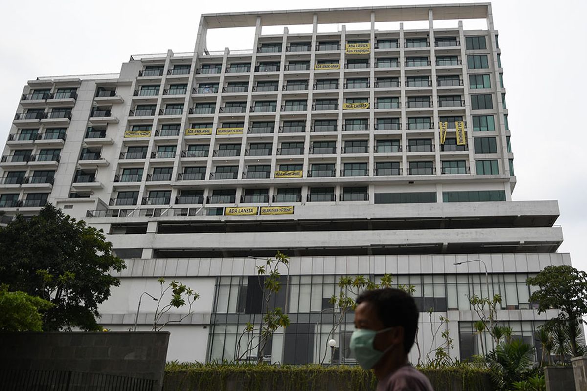 Warga melintas di depan gedung yang terpasang spanduk bertuliskan penolakan atas penggunaan rumah sakit darurat COVID-19 di Lippo Plaza, Mampang, Jakarta, Minggu (5/4/2020). Aksi tersebut sebagai bentuk kekhawatiran penghuni apartemen Nine Residence yang membuat mereka berada dalam zona merah COVID-19.