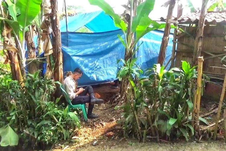 Seorang anggota Polsek Nagrak berjaga di lokasi pembongkaran makam jenazah MA pelajar SMP untuk otopsi di Kampung Selaawi Hilir, Desa Cibunarjaya, Kecamatan Ciambar, Sukabumi, Jawa Barat, Selasa (25/7/2023).