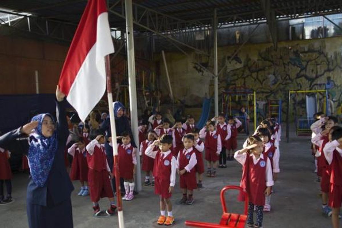 Anak-anak berbaris mengikuti upacara bendera pada hari pertama masuk sekolah di TK Nurmala Hikmah, Pondok Kelapa, Jakarta Timur, Senin (27/7/2015). Peraturan Menteri Pendidikan dan Kebudayaan Nomor 23 Tahun 2015 tentang Penumbuhan Budi Pekerti berisi antara lain tentang keterlibatan orangtua dalam pendidikan anak. Salah satu hal yang ditekankan adalah kewajiban orangtua mengantar anak ke sekolah pada hari pertama tahun ajaran baru.