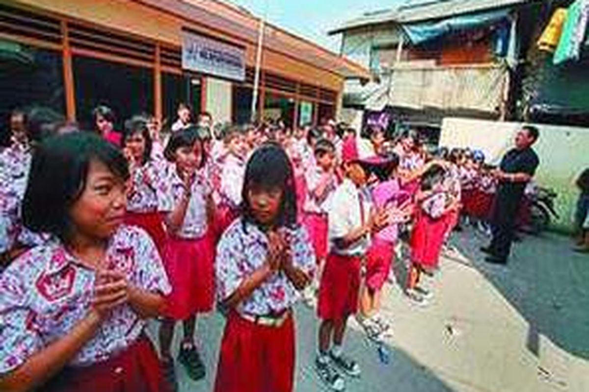 Murid-murid SD Swasta Bintang Pancasila berkumpul di lapangan sekolah mereka yang berada di perkampungan padat penduduk di Kebon Tebu, Muara Baru, Penjaringan, Jakarta.