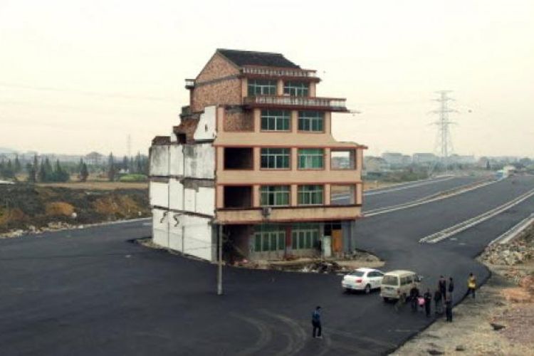 Sebuah rumah berdiri di tengah jalan raya bebas hambatan di kawasan Wenling, China. Sang pemilik menolak semua tawaran ganti rugi pihak kontraktor yang hendak membangun jalan. Alhasil, rumah itu pun berdiri di tengah jalan.