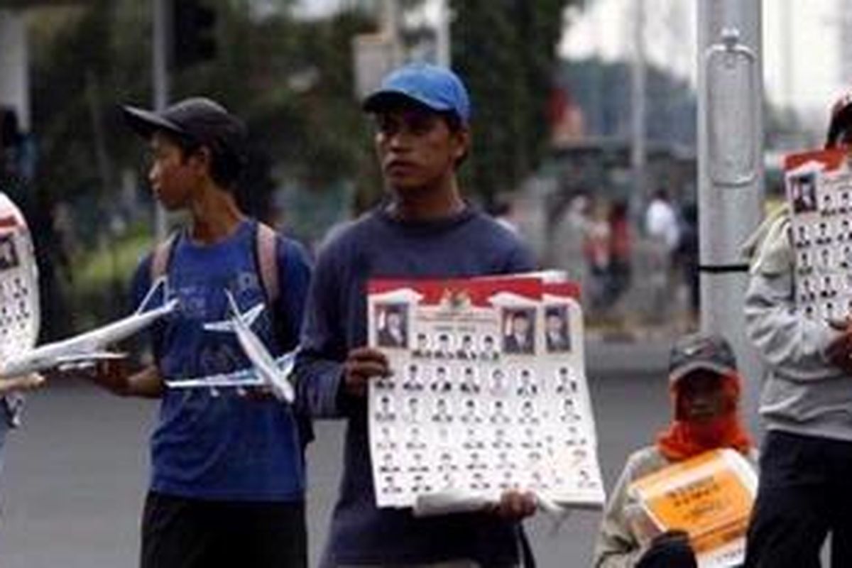 Pedagang menjajakan poster Kabinet Indonesia Bersatu II kepada pengguna jalan di kawasan Senen, Jakarta Pusat, Senin (26/10). Poster ukuran kecil dijual Rp 2.000 per lembar sedangkan yang berukuran besar dijual Rp 5.000 per lembar.