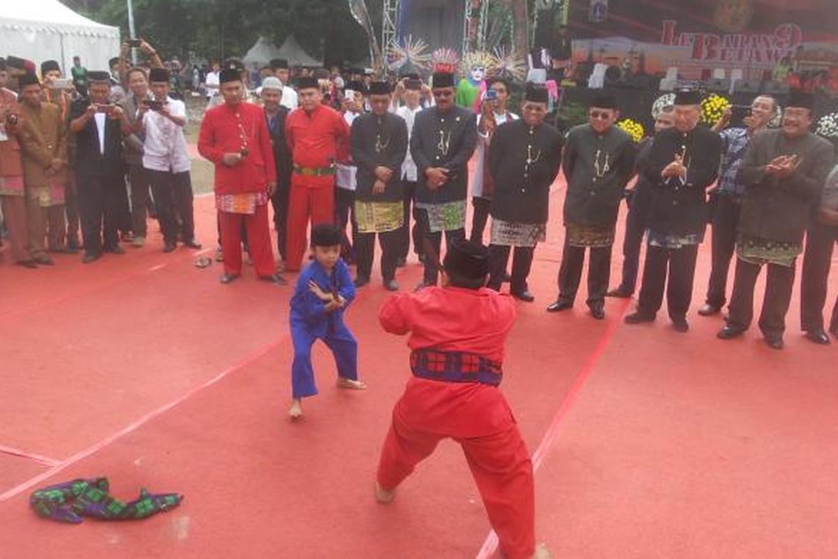 Dua orang anak yang tengah memperagakan jurus silat Betawi dalam acara Lebaran Betawi 2016 di Lapangan Betawi, Gambir, Jakarta Pusat, Minggu (14/8/2016).