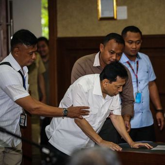 Tersangka kasus korupsi proyek e-KTP, Setya Novanto berbicara dengan penasehat hukumnya pada sidang perdana di Gedung Pengadilan Tipikor, Jakarta, Rabu (13/12/2017). Setya Novanto akan menghadapi sidang pembacaan dakwaan oleh jaksa penuntut umum.