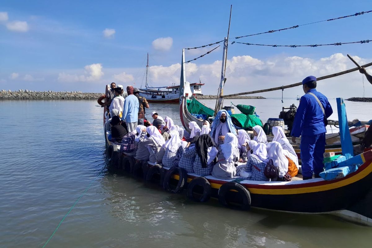 Foto: Para santri dan santriwati ketika diantar menggunakan kapal ojek menuju kapal kayu tradisional untuk pemberangkatan ke Pulau Sapudi Madura pada Selasa (11/4/2023).