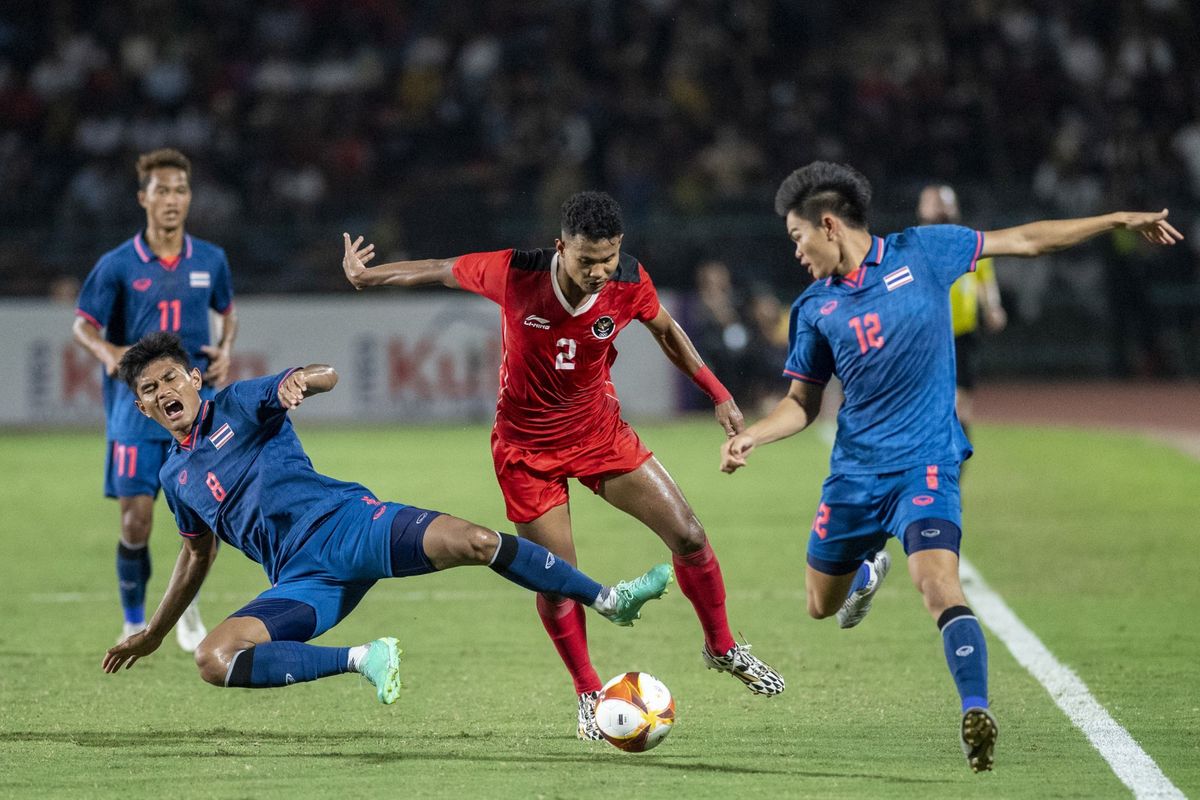 Pesepak bola Timnas U22 Indonesia Amiruddin Bagas Kaffa Arrizqi (tengah) dibayangi pesepak bola Timnas Thailand Apisit Saenseekhammuan (kanan) dan Teerasak Poeiphimai (kiri) saat pertandingan Final Sepak Bola SEA Games 2023 di National Olympic Stadium, Phnom Penh, Kamboja, Selasa (16/5/2023). Indonesia berhasil meraih medali emas setelah mengalahkan Thailand dengan skor 5-2.