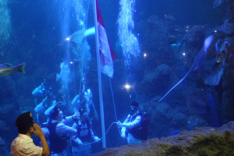 Marsha Aruan (tengah dari pasukan pengibar bendera) melakukan mengibarkan bendera merah putih di Seaworld, Ancol, Jakarta Utara, Jumat (17/8/2018).