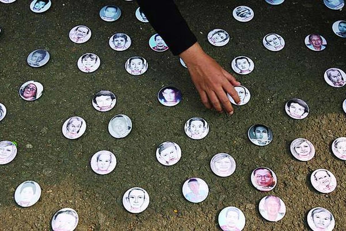 Peserta aksi diam Kamisan ke-138 memasang sejumlah pin bergambar wajah aktivis yang diculik saat aksi di depan Istana Merdeka, Jakarta, Kamis (10/12). Dalam aksi yang bertepatan dengan Hari Hak Asasi Manusia (HAM) Internasional tersebut, para korban dan keluarga korban meminta pemerintah segera mengusut dan menyelesaikan kasus pelanggaran HAM.