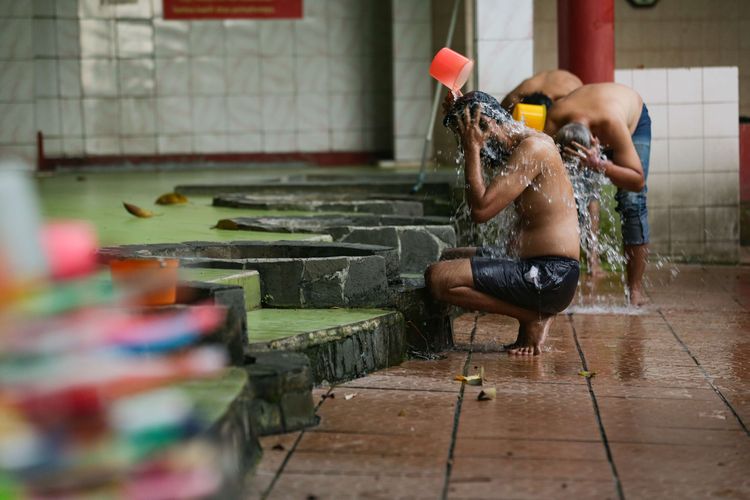 Warga mandi di pemandian Sumur Tujuh di area Vihara Gayatri, Depok, Senin (31/1/2022). Untuk menyambut perayaan Tahun Baru Imlek 2573 yang jatuh Selasa (1/2/2022), warga yang datang ke vihara ini tidak hanya untuk bersembahyang, namun juga mandi dengan air Sumur Tujuh yang dipercaya membawa kesehatan dan kesembuhan serta peruntungan yang lebih baik.