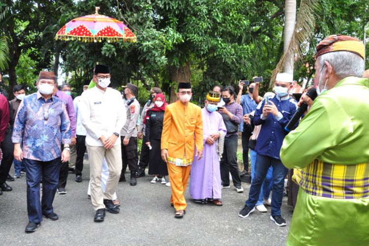 Menteri Pariwisata dan Ekonomi Kreatif Sandiaga Salahuddin Uno (kedua kiri) disambut dengan upacara adat Mopotilolo di halaman rumah jabatan Bupati Gorontalo, Sabtu (6/11/2021). Sandiaga mengunjungi Gorontalo daerah asal leluhurnya untuk meninjau Desa Bongo yang masuk 50 besar Anugerah Desa Wisata Indonesia serta sejumlah obyek wisata.