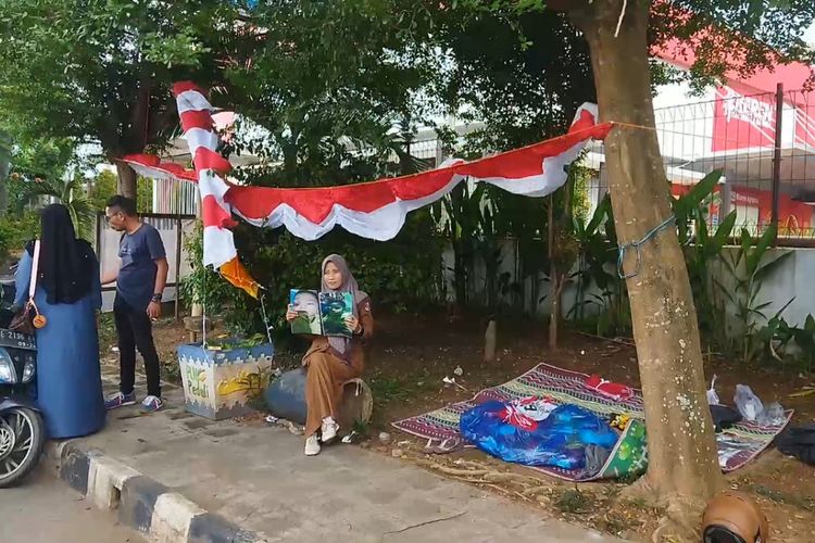 Tri Wahyuningsih (40) seorang kepala sekolah di Desa Sekipi berjualan bendera untuk membantu biaya pengobatan tetangganya yang menderita tumor.