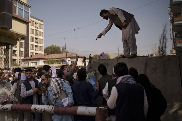 Warga Afghanistan berkumpul di luar kantor paspor pemerintah yang baru mengumumkan akan dibuka kembali setelah Taliban mengumumkan mereka akan mengeluarkan simpanan aplikasi yang disetujui oleh pemerintahan sebelumnya di Kabul, Afghanistan, Rabu, 6 Oktober 2021. 