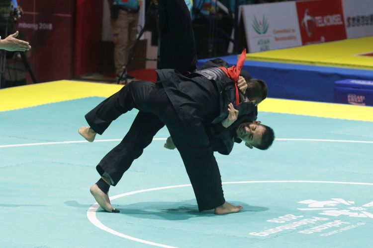 Pesilat Indonesia Iqbal Candra Pratama (sabuk biru) melakukan serangan  kepada pesilat Vietnam Ngoc Toan Nguyen dalam babak final Kelas E Putra Asian Games 2018 di Padepokan Pencak Silat Taman Mini Indonesia Indah (TMII), Jakarta, Senin (27/8/2018). Candra berhasil meraih medali emas cabang olahraga pencak silat kelas 60-65 kilogram.