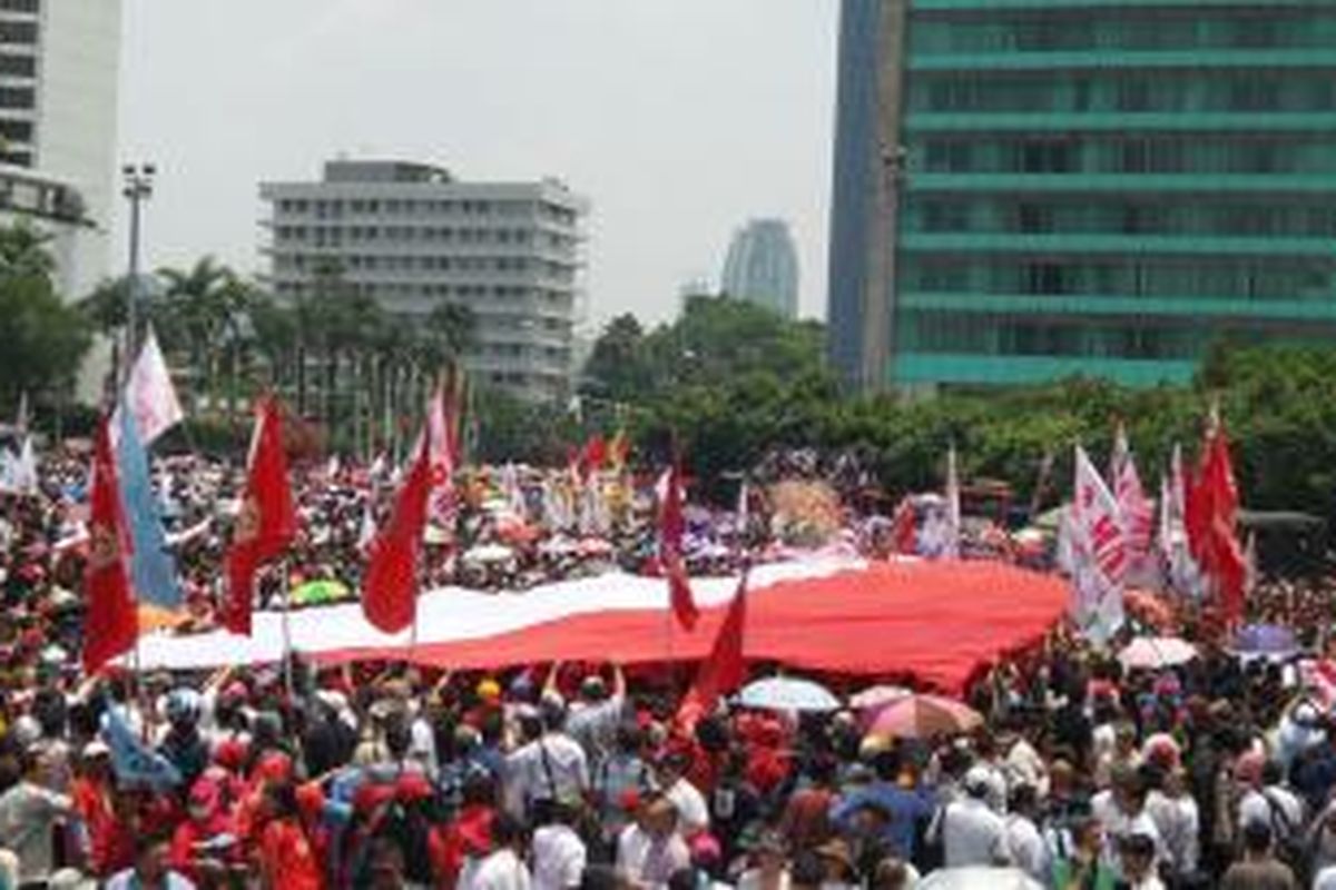 Sebuah bendera Merah Putih berukuran raksasa dibentangkan di kawasan Bundaran HI, Jakarta Pusat, Senin (20/10/2014).