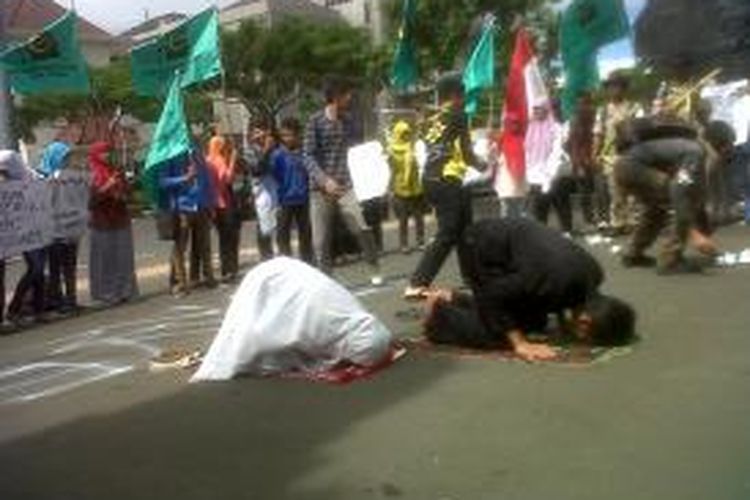 Massa dari Gerakan Pemuda Islam menggelar shalat ghaib dan teatrikal menolak agresi Israel ke Gaza di halaman DPRD Jateng, Senin (14/7/2014).