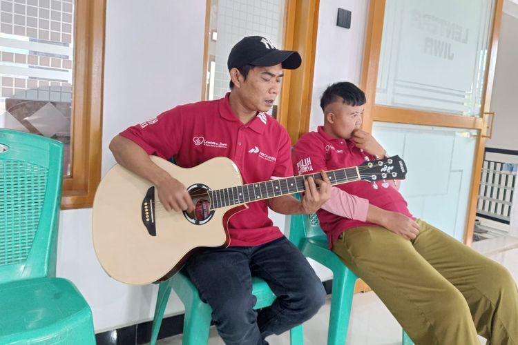 Penyintas ODGJ di Desa Pangauban, Kecamatan Batujajar, Kabupaten Bandung Barat, sedang bermain gitar. 