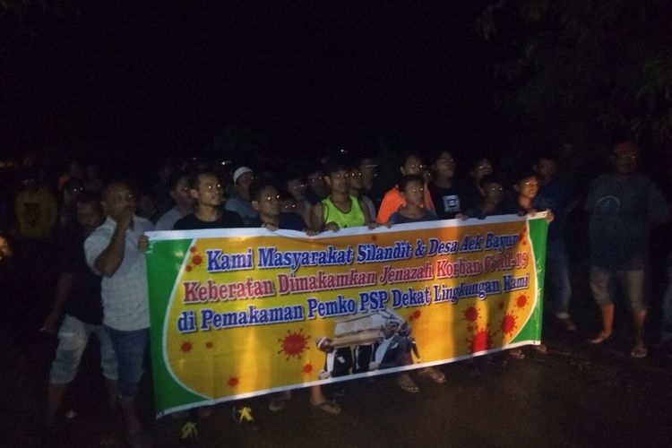 Puluhan warga Desa Aek Bayur dan Kelurahan Silandit, Kota Padangsidimpuan melakukan aksi protes dan menghadang jalan menolak jenazah Covid-19 dimakamkan di lingkungan mereka, Senin (31/8/2020)