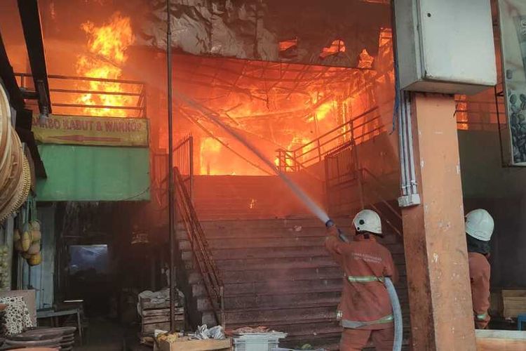Petugas Pemadam Kebakaran Saat Memadamkan Kobaran Api di Pasar Kembang Surabaya, Minggu Sore (22/8/2021).
