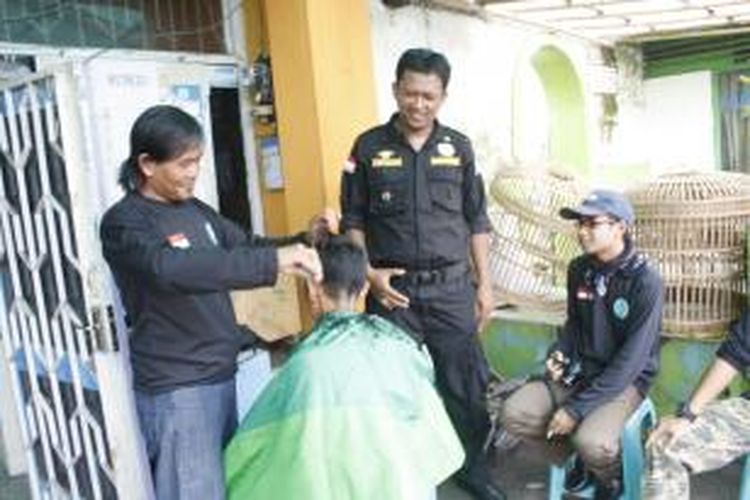 Caleg DPRD Kota Magelang dari PKB, Luky Henri Yuni Susanto, membuka layanan jasa potong rambut gratis di halaman rumahnya pada kampanye terakhir di Kota Magelang, Sabtu (5/4/2014).