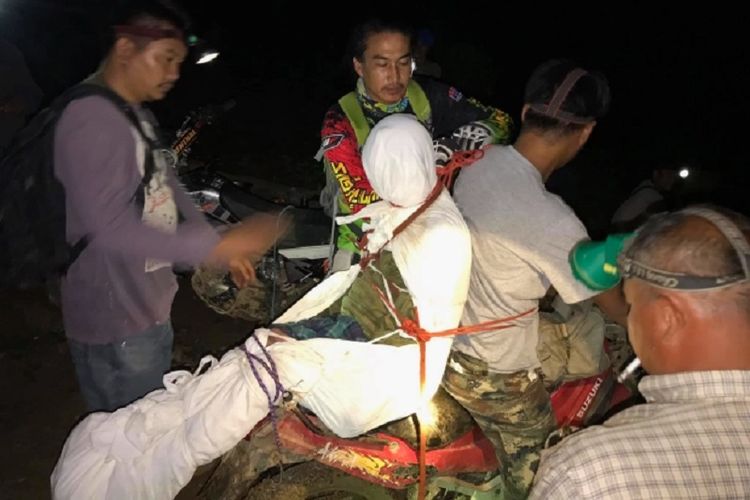 Jenazah seorang perempuan diikat di belakang sepeda motor sebelum dibawa ke rumah duka di Thailand. Perempuan itu disebut tewas terperangkap ketika hendak mencuri makanan.