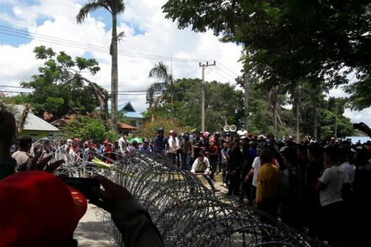 Ratusan massa pendukung salah satu calon walikota Kendari mencoba menerobos kawat berduri untuk masuk ke KPU Sultra. ( KOMPAS.COM/KIKI ANDI PATI)