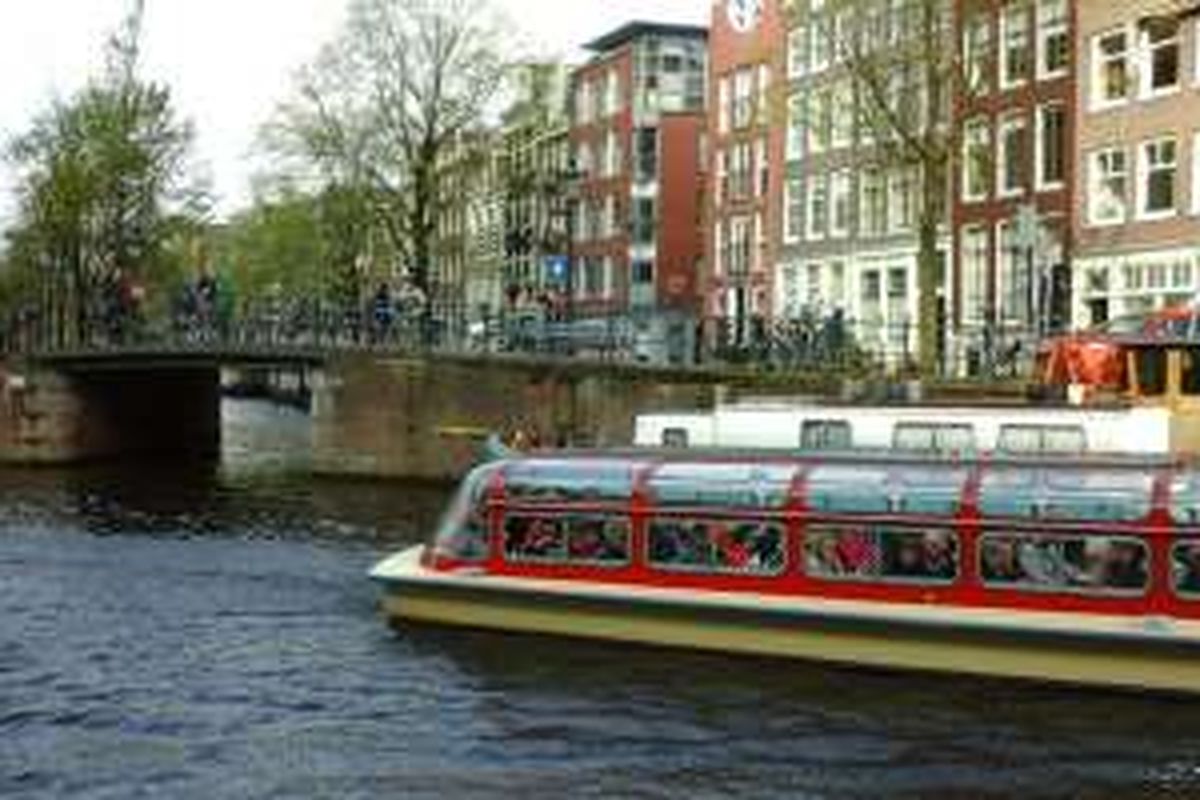 Wisata air di kanal Amsterdam. Kanal-kanal ini begitu terawat dan menjadi obyek wisata.