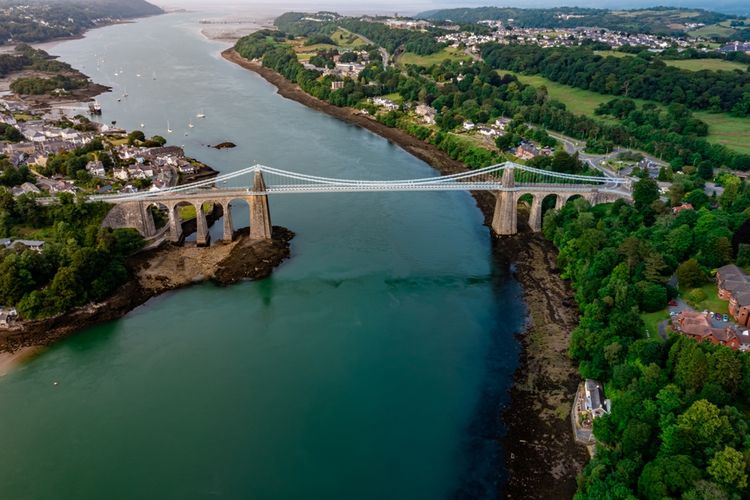 Menai Bridge, membentang melintasi Selat Menai di Wales. Jembatan gantung pertama di dunia dan dibuka untuk umum pada 1826