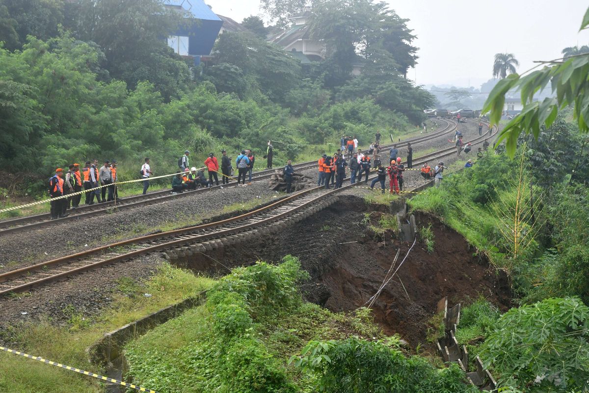 Sejumlah warga dan petugas melihat kondisi tanah longsor di jalur rel Kereta Api (KA) Pangrango lintas Bogor-Sukabumi di Kelurahan Empang, Kota Bogor, Jawa Barat, Rabu (15/3/2023). Tanah longsor yang disebabkan curah hujan yang tinggi di wilayah Kota Bogor pada Selasa (14/3/) malam itu mengakibatkan jalur rel kereta api sepanjang 25 meter menggantung sehingga seluruh perjalanan KA Pangrango lintas Bogor-Sukabumi (PP) dibatalkan.