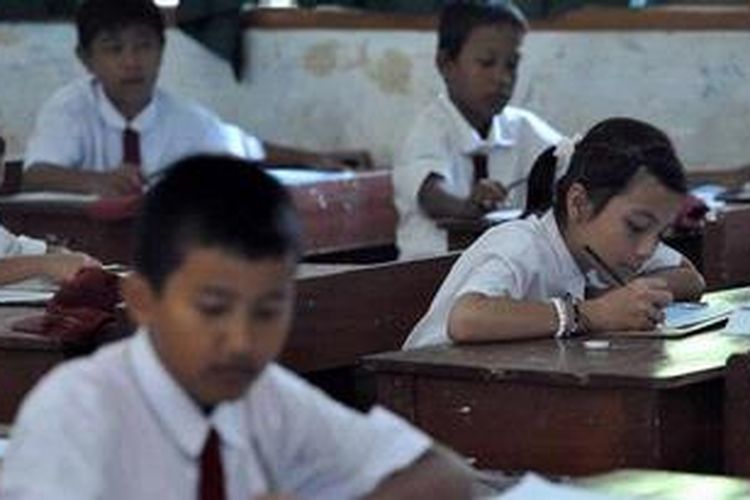 Murid SDN Kemiri Muka 02, Beji, Depok, mengerjakan soal Bahasa Indoensia pada hari pertama ujian nasional di sekolah mereka, Senin (6/5/2013). Pelaksanaan ujian nasional di sekolah ini lancar yang diikuti 19 siswa.