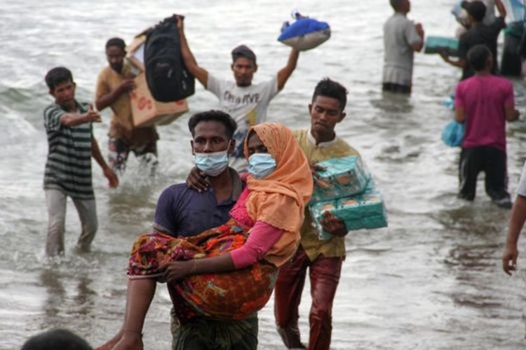 Warga melakukan evakuasi paksa pengungsi etnik Rohingya dari kapal di pesisir pantai Lancok, Kecamatan Syantalira Bayu, Aceh Utara, Aceh, Kamis (25/06). 