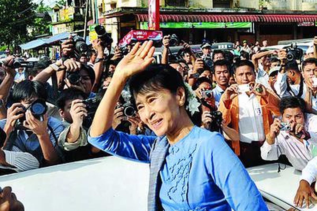 Ikon demokrasi Myanmar, Aung San Suu Kyi (tengah), melambaikan tangan kepada para pendukungnya dalam sebuah kunjungan ke Bago, sekitar 80 kilometer utara Yangon, Minggu (14/8). Ini adalah kunjungan politiknya yang pertama sejak ia dibebaskan dari tahanan rumah.