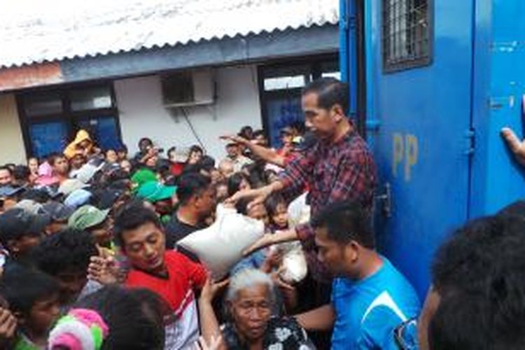 Gubernur DKI Jakarta Joko Widodo saat membagikan sembako ke warga di Kampung Nelayan, Minggu (2/2/2014).