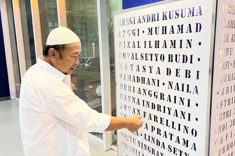 Nuri Hidayat saat menunjukkan nama-nama korban Tragedi Kanjuruhan yang diabadikan di area Gate 13 Stadion Kanjuruhan.