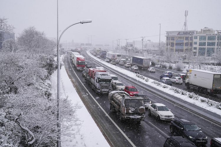 Mobil melaju di jalan raya selama hujan salju, utara Athena, pada Senin, 24 Januari 2022. 