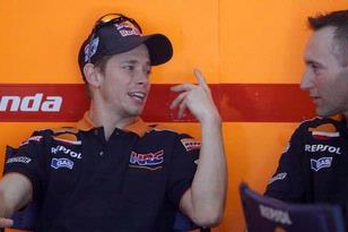 Pebalap Repsol Honda, Casey Stoner (kiri), berbincang dengan anggota timnya, saat latihan resmi pra-musim MotoGP 2012 di Sepang, Selasa (31/1/12).