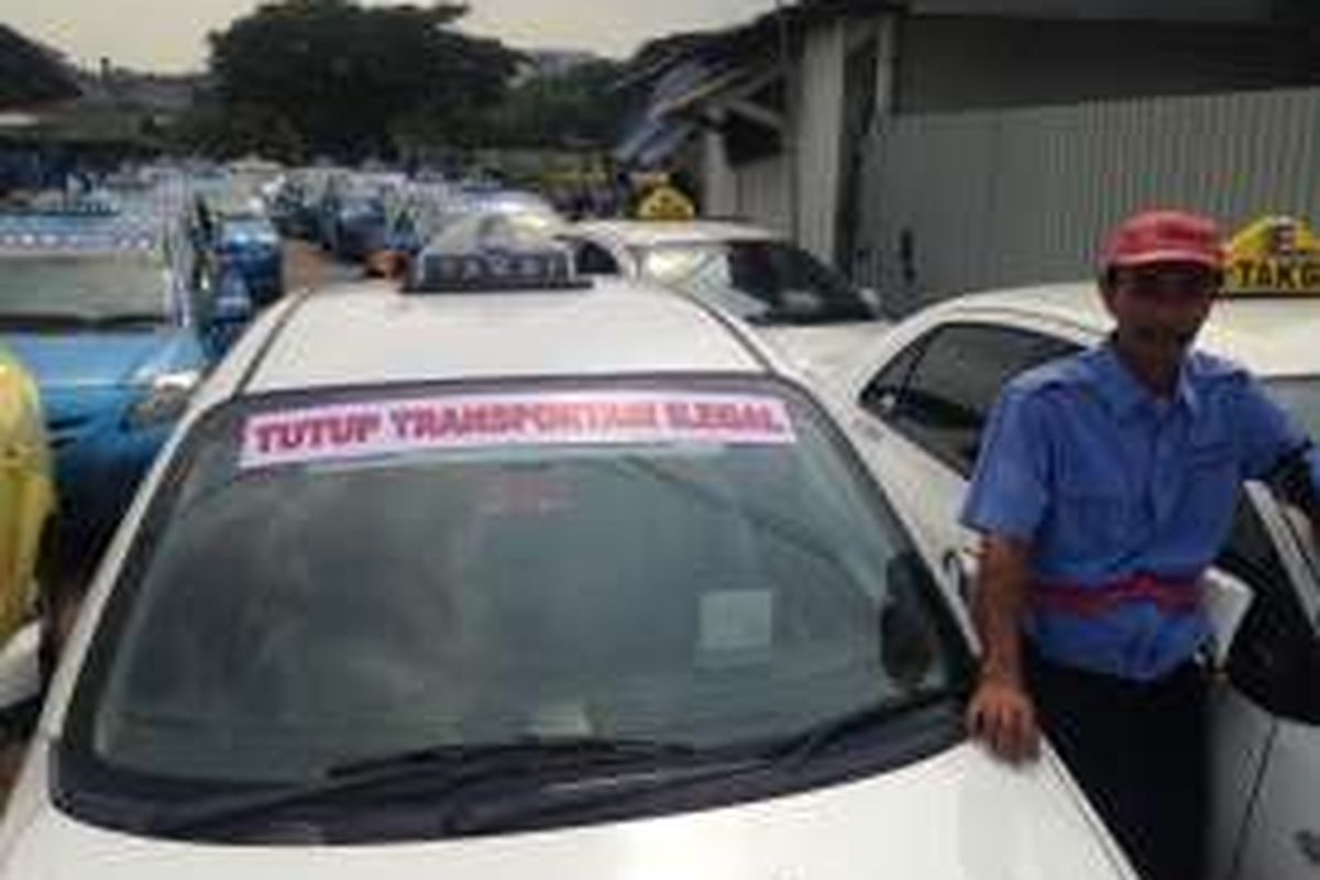 Tampak sejumlah taksi yang dipasang stiker memprotes jasa transportasi secara online yang dianggap ilegal oleh sopir taksi di dekat tol Bandara Soekarno-Hatta arah Jakarta, Senin (14/3/2016). Sebagian besar sopir taksi mogok kerja dan ikut unjuk rasa menentang keberadaan Uber dan Grab serta menuntut revisi peraturan tentang peremajaan armada. 





