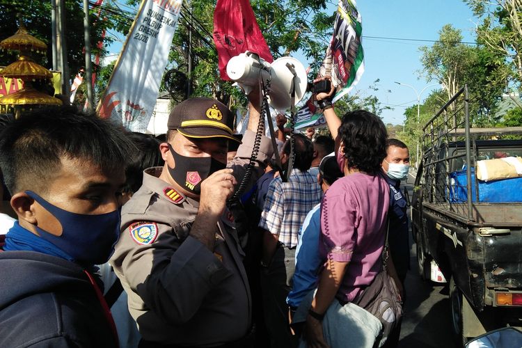 Kasat Binmas Polres Gresik AKP Zunaidi, saat memberikan himbauan kepada massa pendukung Paslon yang ada di luar gedung KPU Gresik agar tetap mematuhi protokol kesehatan, Jumat (4/9/2020).