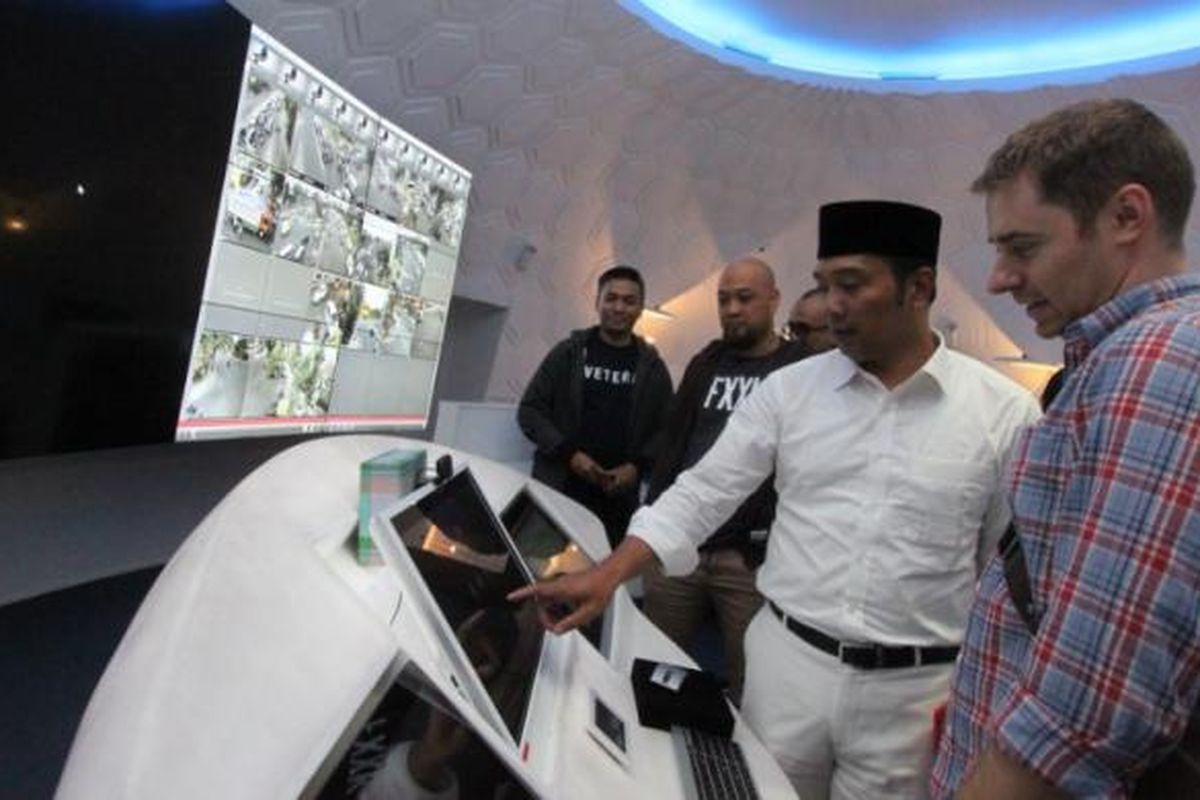 Wali Kota Bandung Ridwan Kamil saat memamerkan teknologi di Bandung Command Center kepada salah seoarang tamu asal luar negeri. 