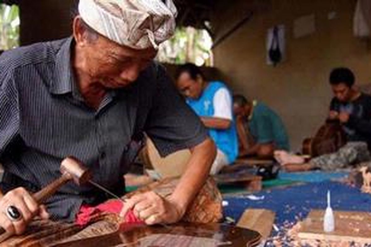 Perajin gitar berlabel Blueberry, I Wayan Tuges saat bekerja menyelesaikan gitar ukir, di workshopnya desa Guwang, Sukawati, Gianyar, Bali, Selasa (16/8/2011). Gitar ukir yang ia produksi dijual dengan kisaran harga antara 2.000 hingga 6.500 dollar AS dan pemasarannya telah menembus Kanada, Amerika Serikat dan beberapa negara di Eropa.  