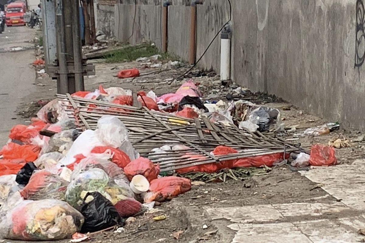 Kondisi trotoar di Pasar Induk Cibitung, Kabupaten Bekasi, Senin (5/6/2023). Terlihat dari pandangan mata, masih banyak sampah yang berserakan. Sampah didominasi plastik rumah tangga, terlihat ada yang membuat pagar kayu di tempat pembuangan sampah (TPS) liar tersebut. 