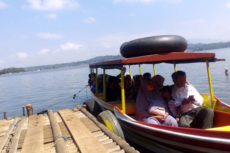 Para wisatawan naik perahu keliling untuk menikmati panorama Waduk Darma, Senin (10/06/2019).