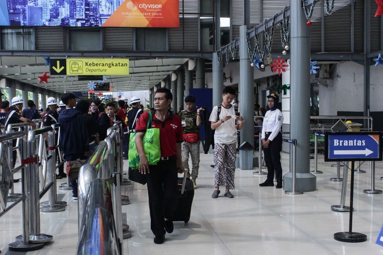 Seorang porter membawa barang milik penumpang yang ingin menaiki kereta api di Stasiun Pasar Senen, Senen, Jakarta Pusat, Sabtu (21/12/2019). PT KAI menambah 13 kereta reguler yang dioperasikan guna mengantisipasi lonjakan penumpang selama Natall 209 dan Tahun Baru 2020.