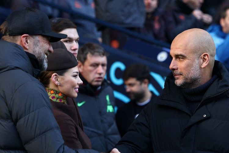 Pep Guardiola (kanan) bersalaman dengan Juergen Klopp dalam laga pekan ke-13 Liga Inggris 2023-2024 antara Man CIty vs Liverpool di Stadion Etihad, Sabtu (26/11/2023). (Photo by Darren Staples / AFP).