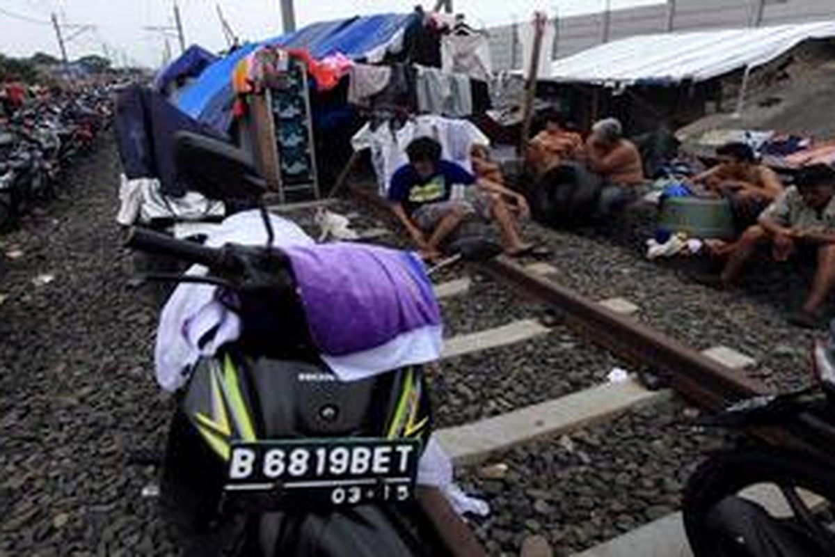Ratusan keluarga warga Rawa Buaya, Jakarta Barat, mengungsi di atas rel kereta api dan tanggul Kali Pesanggrahan, akibat meluapnya Kali Pesanggrahan, Jumat (18/1/2013). Warga yang telah mengungsi sejak Rabu (16/1/2013) lalu itu, belum mendapat bantuan dari pemerintah daerah.

