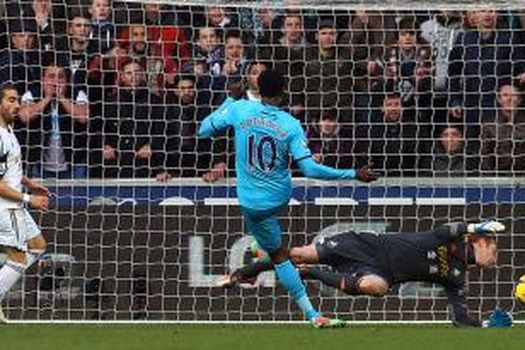 Striker Tottenham Hotspur, Emmanuel Adebayor, saat melepaskan tendangan yang berujung gol ke gawang Swansea City pada lanjutan Premier League di Stadion Liberty, Minggu (19/1/2014). Tottenham menang 3-1 pada pertandingan tersebut. 